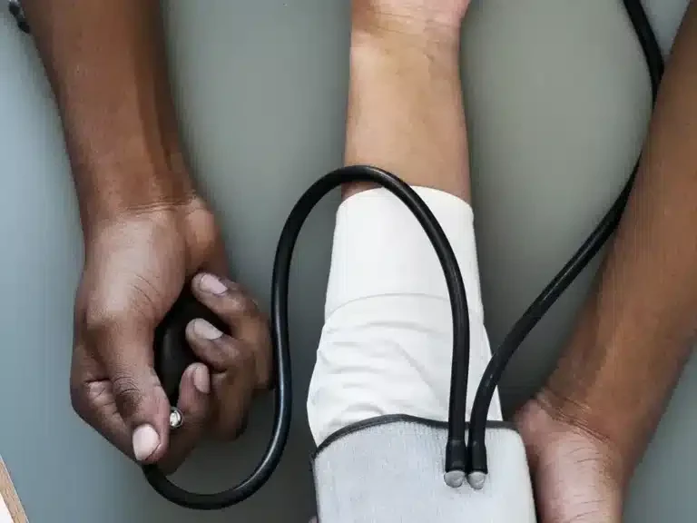 Health worker checking a patient's blood pressure with an arm cuff