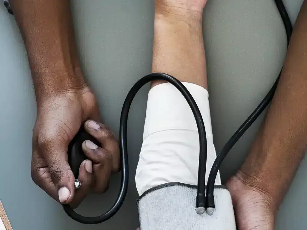 Health worker checking a patient's blood pressure with an arm cuff