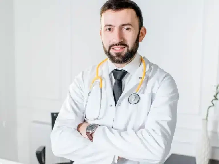 Doctor in a white coat with a stethoscope standing in a consulting room