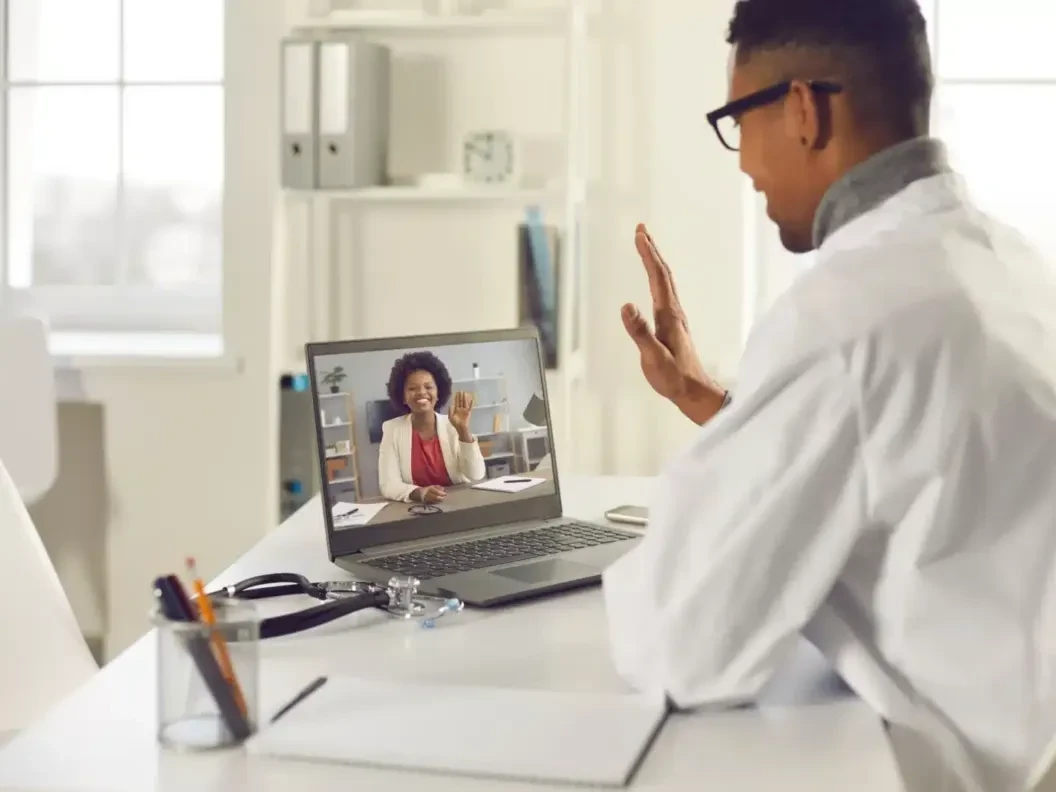 GP greeting a patient on a laptop during a video consultation