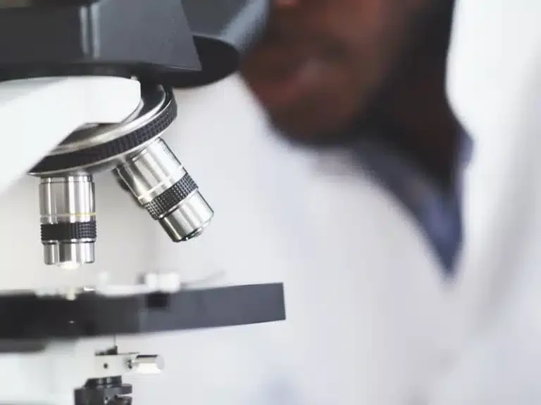 Laboratory technician examining a patient sample under a microscope