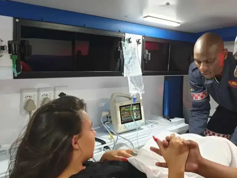 A Ralmed paramedic monitoring a patient inside an ambulance