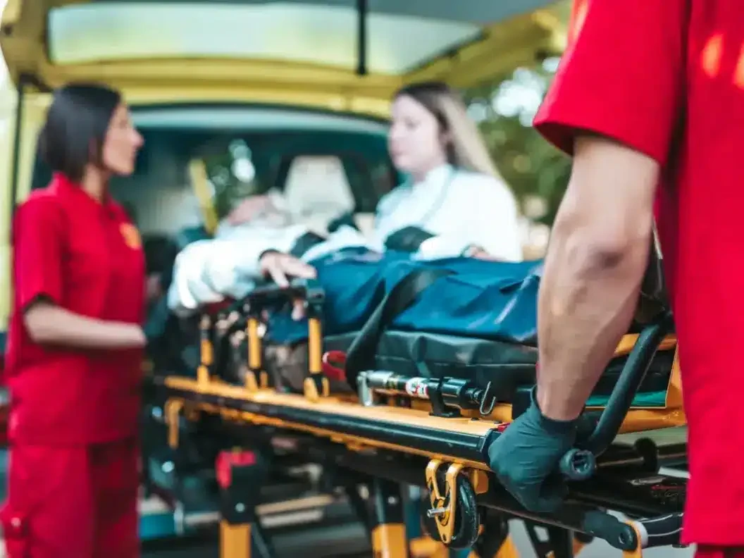 Paramedics loading a patient into an ambulance as part of casualty department support