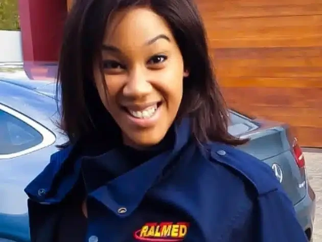 Smiling Ralmed paramedic in a navy uniform with a South African flag badge